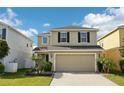 Two-story home featuring a two-car garage, neutral paint, black shutters, and tasteful landscaping at 11301 Hudson Hills Ln, Riverview, FL 33579