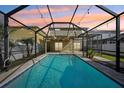 Inviting screened pool with string lights, perfect for evening relaxation and outdoor enjoyment at 11301 Hudson Hills Ln, Riverview, FL 33579