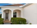 Inviting front porch with decorative pillars, manicured bushes, and a cozy entrance to welcome visitors at 11822 Crawford Parrish Ln, Parrish, FL 34219