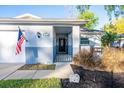 Inviting front entrance with decorative gate, charming landscape, and American flag at 13116 Sheridan Dr, Hudson, FL 34667