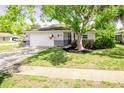 Well-kept home exterior with a lush lawn and a beautiful, mature tree at 13116 Sheridan Dr, Hudson, FL 34667