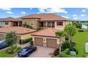 This exterior shot highlights the attached garages, landscaping, and Spanish tile roof at 13823 Messina Loop # 204, Bradenton, FL 34211