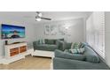 Comfortable living room with a large sectional sofa, wall-mounted TV, and bright natural light at 17035 Gulf Blvd # 202, North Redington Beach, FL 33708