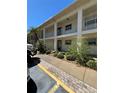 This exterior shot showcases a two-story apartment building with private balconies and lush landscaping at 19029 Us Highway 19 N # 2-12, Clearwater, FL 33764