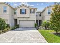 Charming townhome featuring a paved driveway, two-car garage, and well-maintained landscaping at 19398 Great Intention Way, Lutz, FL 33558