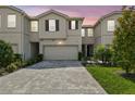 Charming townhome with a two-car garage, beautiful landscaping, and a paver driveway at 19398 Great Intention Way, Lutz, FL 33558