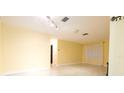 Bright living room offering an open floor plan, neutral paint, and large windows for natural lighting at 2118 Ne Coachman Rd, Clearwater, FL 33765