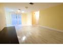 An airy living room featuring light wood floors, ample natural light from large windows, and neutral wall paint at 2118 Ne Coachman Rd, Clearwater, FL 33765