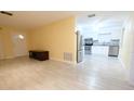 Open-concept living space showcases a seamless transition to the modern kitchen with stainless steel appliances and white cabinetry at 2118 Ne Coachman Rd, Clearwater, FL 33765