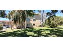 Exterior view of a building with well-maintained lawn and shade trees at 2402 Ecuadorian Way # 20, Clearwater, FL 33763