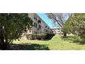 A side exterior view showcases well-maintained landscaping surrounding the building at 2402 Ecuadorian Way # 20, Clearwater, FL 33763