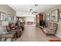 Spacious living room flowing into the dining area, featuring tile flooring and a ceiling fan at 2490 E Vina Del Mar Blvd, St Pete Beach, FL 33706