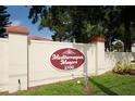 Mediterranean Manors community sign on a white wall with green grass in front at 2700 Bayshore Blvd # 588, Dunedin, FL 34698