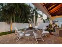 Cozy up in your outdoor living space with a stone fire pit surrounded by comfortable white Adirondack chairs at 3006 W Angeles St, Tampa, FL 33629