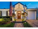 Inviting entryway featuring a wood door with glass inserts, flanked by decorative plants and an American flag at 3006 W Angeles St, Tampa, FL 33629