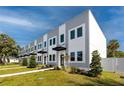 Modern townhomes with gray and white exterior, black awnings, and landscaped front yards at 3402 E 28Th Ave # 4, Tampa, FL 33605