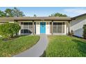 Inviting home exterior featuring a vibrant blue front door and meticulously maintained landscaping at 4065 38Th S St, St Petersburg, FL 33711