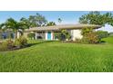 Well-maintained home showcasing lush green lawn and a bright blue front door at 4065 38Th S St, St Petersburg, FL 33711