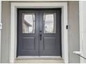 Close up of the front door with glass paneled doors and a Ring doorbell at 4307 Dristol Ave, Spring Hill, FL 34609