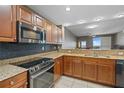Spacious kitchen with granite countertops, stainless steel appliances, sleek backsplash, and wood cabinets at 628 Cleveland St # 1208, Clearwater, FL 33755