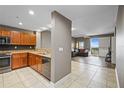 Modern kitchen with stainless steel appliances, wood cabinets, mosaic backsplash, and an open view to the living area at 628 Cleveland St # 1208, Clearwater, FL 33755