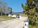 Single-story home with a spacious driveway and mature tree at 7205 Mayfield Dr, Port Richey, FL 34668