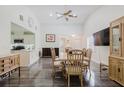 Bright dining area with wood floors, ceiling fan, and open access to living areas and kitchen at 11521 Rose Tree Dr, New Port Richey, FL 34654