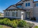 Beautiful home entrance with manicured landscaping, stone accents, and a paver walkway at 12808 Boggy Creek Dr, Riverview, FL 33579