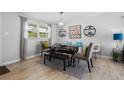 Bright dining room features a modern light fixture, wood flooring, and shelving at 133 15Th Nw St, Largo, FL 33770