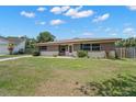 Charming single-story home with a well-maintained lawn and welcoming front entrance at 1542 Picardy Cir, Clearwater, FL 33755