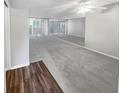 Bright, spacious living room with carpet and mirrored wall, offering an open and airy feel with lots of natural light at 19029 Us Highway 19 N # 6-3, Clearwater, FL 33764