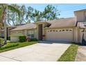 Inviting home boasts a 2-car garage, a well-maintained lawn, and lush greenery, creating a welcoming curb appeal at 3056 Pepperwood W Ln, Clearwater, FL 33761