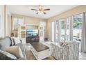 Bright living room featuring stylish furniture, a ceiling fan, and expansive windows with backyard views at 3503 Williston Loop, Land O Lakes, FL 34639