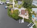 Aerial shot shows a waterfront property with manicured landscaping, a boat dock, and an outdoor seating area at 378 Tennessee Ave, Crystal Beach, FL 34681
