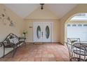 Welcoming front porch with double doors, tiled flooring, and wrought-iron furniture creates a cozy entry at 378 Tennessee Ave, Crystal Beach, FL 34681