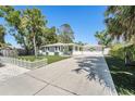 Well-kept single-story home with a long driveway and manicured lawn with a charming picket fence at 4846 Highland S St, St Petersburg, FL 33705