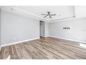 Open living room featuring hardwood floors, tray ceiling with fan, and neutral paint at 5502 Liberty Plain Cir, Tampa, FL 33611