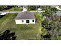 Aerial view showcasing the backyard with a sliding glass door, a small patio, and green grass at 6422 Towhlen Rd, North Port, FL 34291