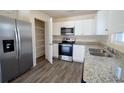 Modern kitchen with stainless steel appliances, white cabinets, granite countertops, and walk-in pantry at 6422 Towhlen Rd, North Port, FL 34291