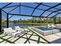 The covered patio has a hot tub, lounge chairs in the water, and artificial grass accents at 9133 Warm Springs Cir, Parrish, FL 34219
