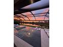 Screened pool overlooking a serene lake provides relaxation and picturesque sunset views at 9133 Warm Springs Cir, Parrish, FL 34219