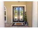 Elegant glass front doors, set on brick, welcome you into the home at 10905 Elliot St, Riverview, FL 33578