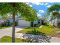Well-maintained home with lush landscaping, a spacious driveway, and a welcoming front entrance at 11221 Gold Compass St, Gibsonton, FL 33534