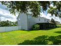 Spacious backyard with an enclosed patio, lush green lawn, and white fencing at 1807 Raven Manor Dr, Dover, FL 33527
