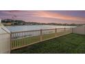 Backyard features a white fence and a serene view of a lake and neighboring homes at 18184 Turning Leaf Cir, Land O Lakes, FL 34638