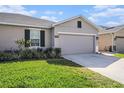 Charming single-story home with a well-manicured lawn and attached two-car garage at 18184 Turning Leaf Cir, Land O Lakes, FL 34638