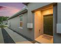 Stucco exterior of home featuring a front door with 'Dogs Welcome' mat and adjacent window at 18184 Turning Leaf Cir, Land O Lakes, FL 34638