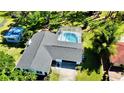 Backyard aerial view of home showing screened pool, shed, and surrounding trees at 210 Lake Hobbs Rd, Lutz, FL 33548