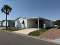 Well-maintained home with a carport, a concrete driveway, and a beautiful palm tree at 215 S Port Royal Ln, Apollo Beach, FL 33572