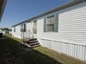 Charming mobile home featuring white siding, blue shutters, and a welcoming front entrance at 215 S Port Royal Ln, Apollo Beach, FL 33572